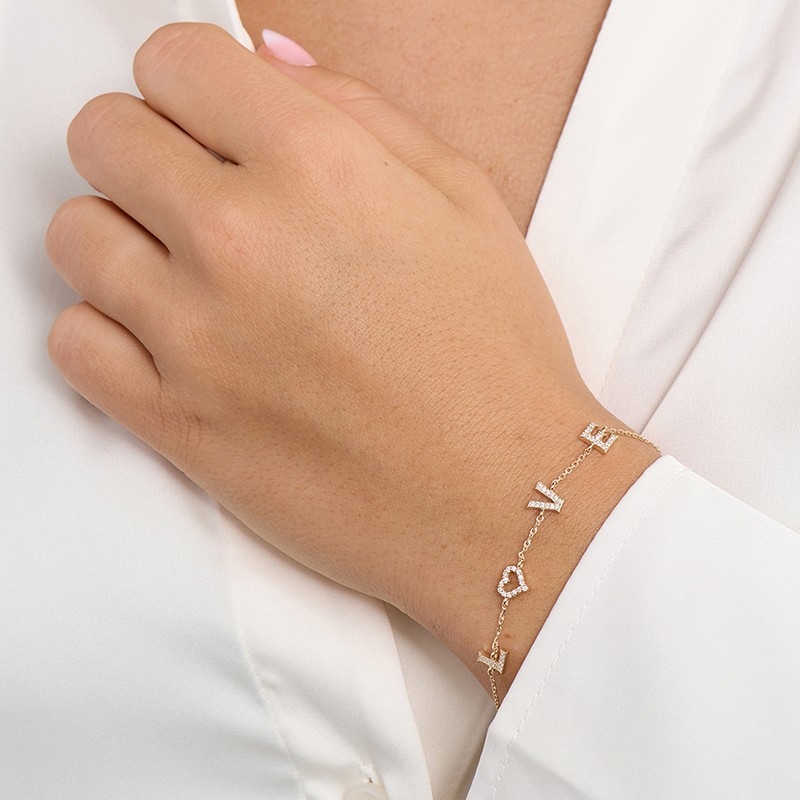Mads Z Tender Love armbånd i 14 kt guld med 0,14 ct W/SI diamanter og LOVE design båret på model